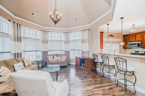 a living room with furniture a flat screen tv and kitchen view