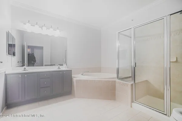 a bathroom with a bathtub a double vanity sink and mirror