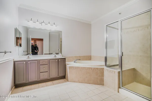 a spacious bathroom with a tub sink and mirror