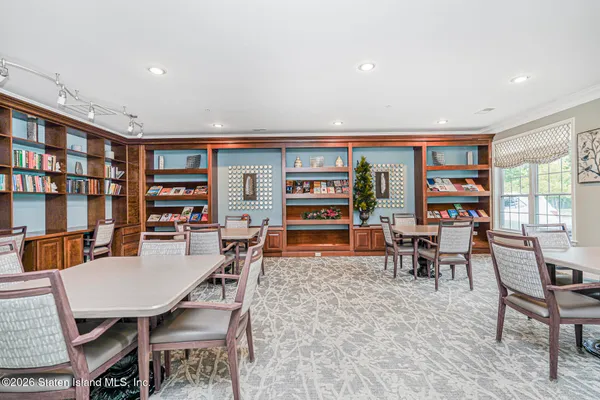 a living room with furniture a rug and a book shelf