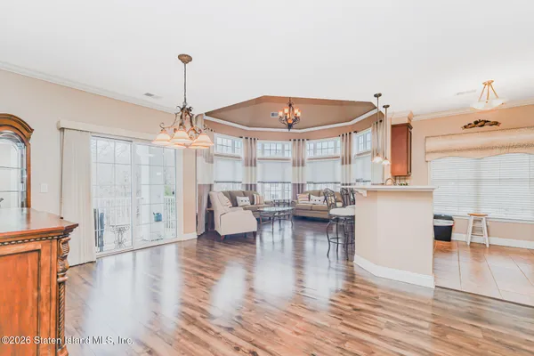a dining room with chandelier fan and wooden floor