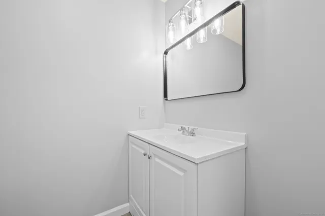 a utility room with a sink a mirror and a vanity