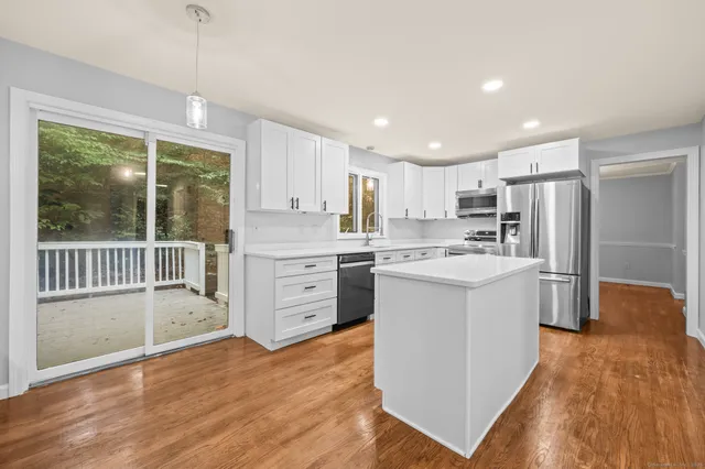 a kitchen with a refrigerator a sink and a stove top oven