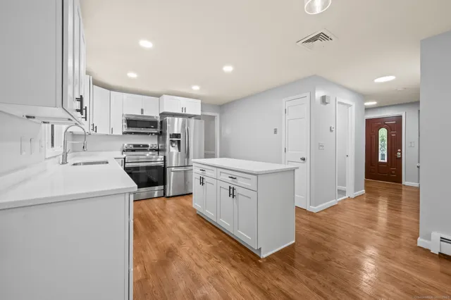 a kitchen with stove a sink and a refrigerator