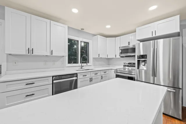 a kitchen with stainless steel appliances granite countertop a refrigerator sink and cabinets