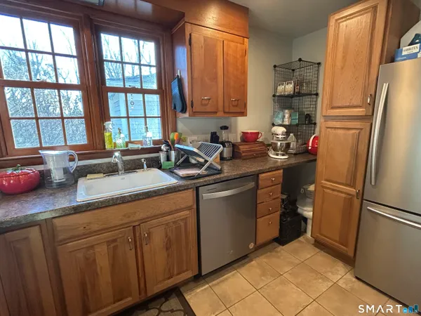 a kitchen with a sink refrigerator and window