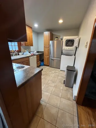 a kitchen with stainless steel appliances granite countertop a refrigerator and a counter top space