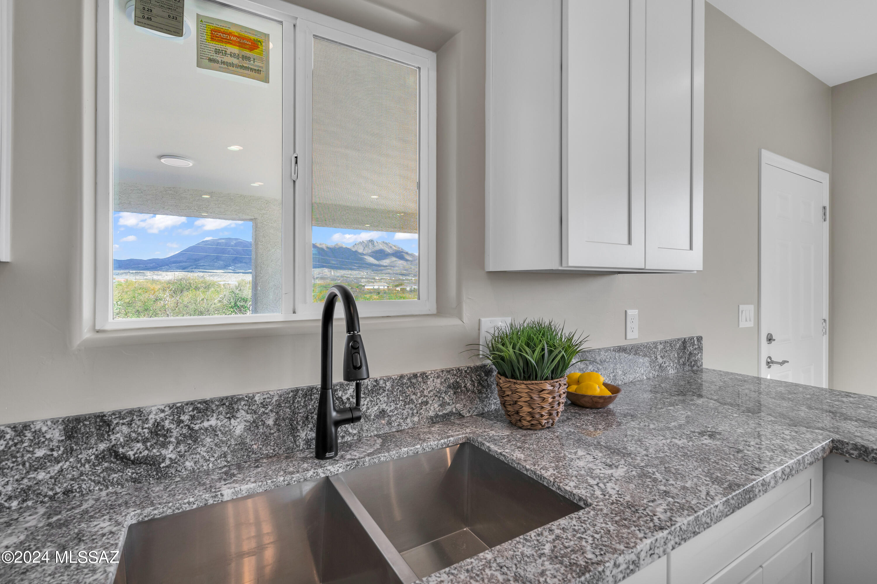 103 Headge Court Rio Rico, AZ 85648 - Photo 7 of 35 a kitchen with a sink a counter top space and cabinets