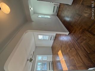 733 East Walnut Street, Unit UPPR Long Beach, NY 11561 - Photo 5 of 26 an empty room with wooden floor and windows