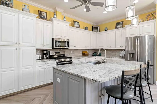 a kitchen with kitchen island granite countertop a sink a center island and stainless steel appliances