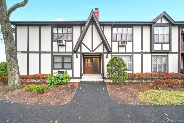 a front view of a house with a yard and potted plants