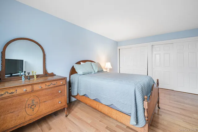 a bedroom with a bed and a flat tv screen on dresser