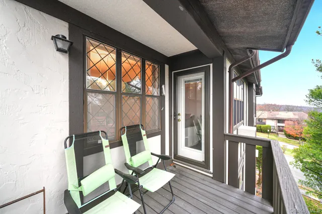 a balcony with wooden floor and outdoor seating