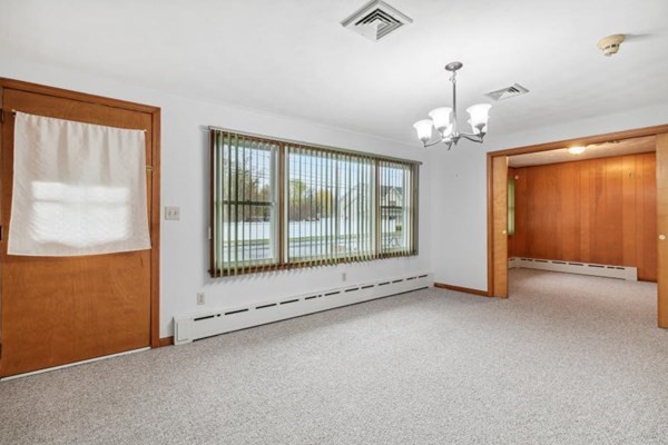 189 Brook Street Clinton, MA 01510 - Photo 7 of 29 an empty room with chandelier outdoor space and windows