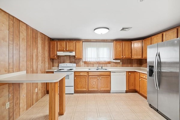 189 Brook Street Clinton, MA 01510 - Photo 9 of 29 a kitchen with stainless steel appliances granite countertop a refrigerator a sink dishwasher a stove and white cabinets with wooden floor