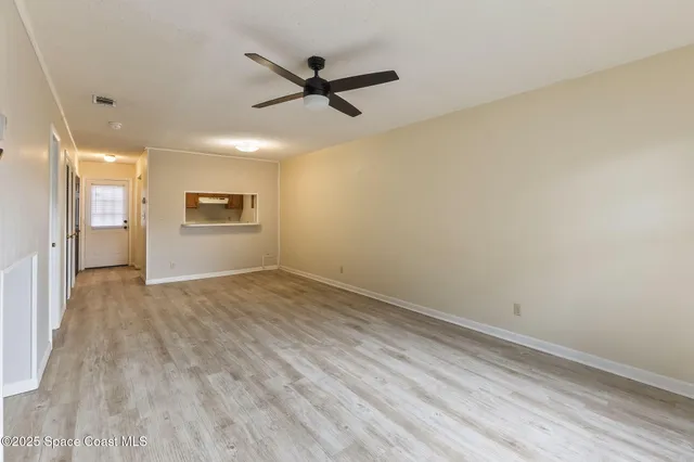 a view of a livingroom with a hardwood floor and a ceiling fan