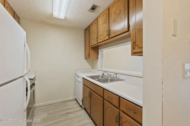 a kitchen with stainless steel appliances granite countertop a sink and a refrigerator