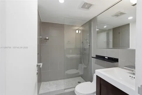 a bathroom with a sink toilet vanity and shower