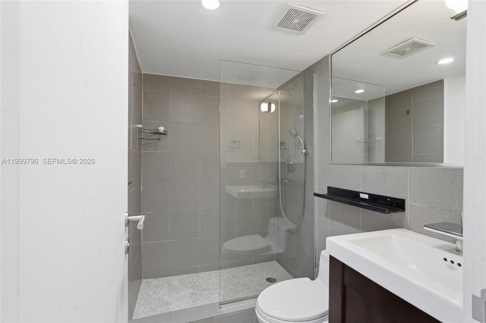 1627 Brickell Avenue, Unit 603 Miami, FL 33129 - Photo 12 of 29 a bathroom with a sink toilet vanity and shower