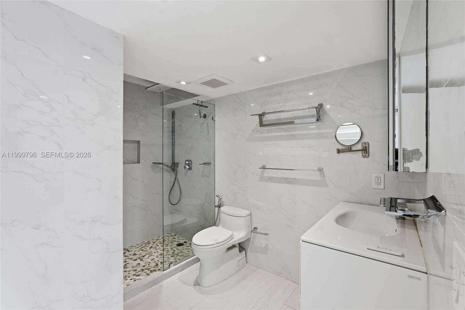 1627 Brickell Avenue, Unit 603 Miami, FL 33129 - Photo 23 of 29 a bathroom with a granite countertop toilet sink and shower