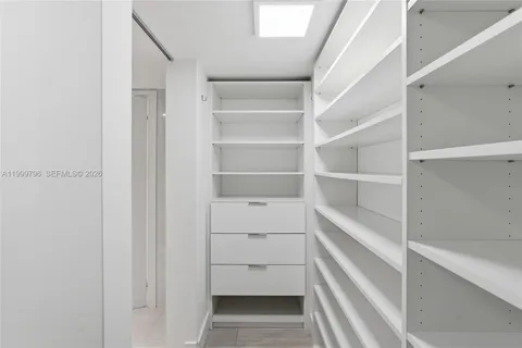 a view of walk in closet with empty racks