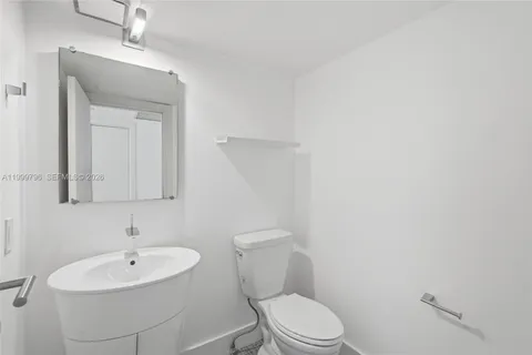 a bathroom with a toilet a sink and mirror