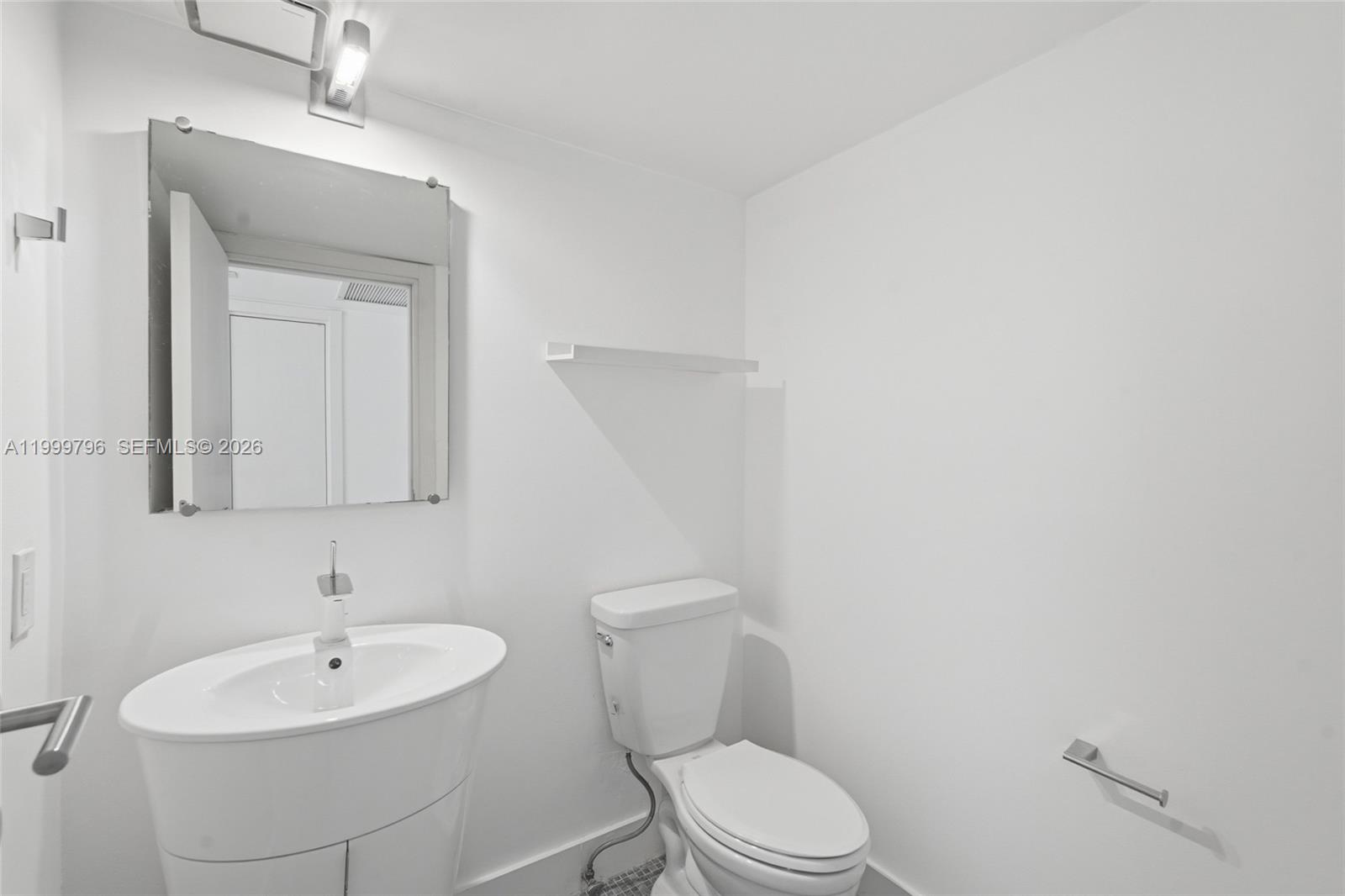 1627 Brickell Avenue, Unit 603 Miami, FL 33129 - Photo 27 of 29 a bathroom with a toilet a sink and mirror