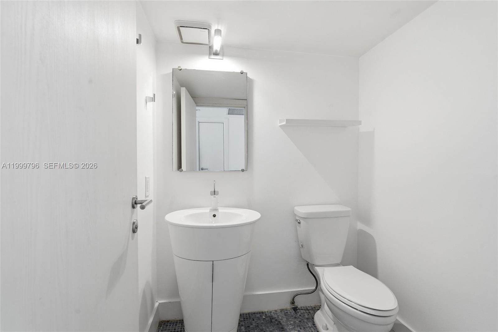 1627 Brickell Avenue, Unit 603 Miami, FL 33129 - Photo 28 of 29 a bathroom with a toilet sink and mirror