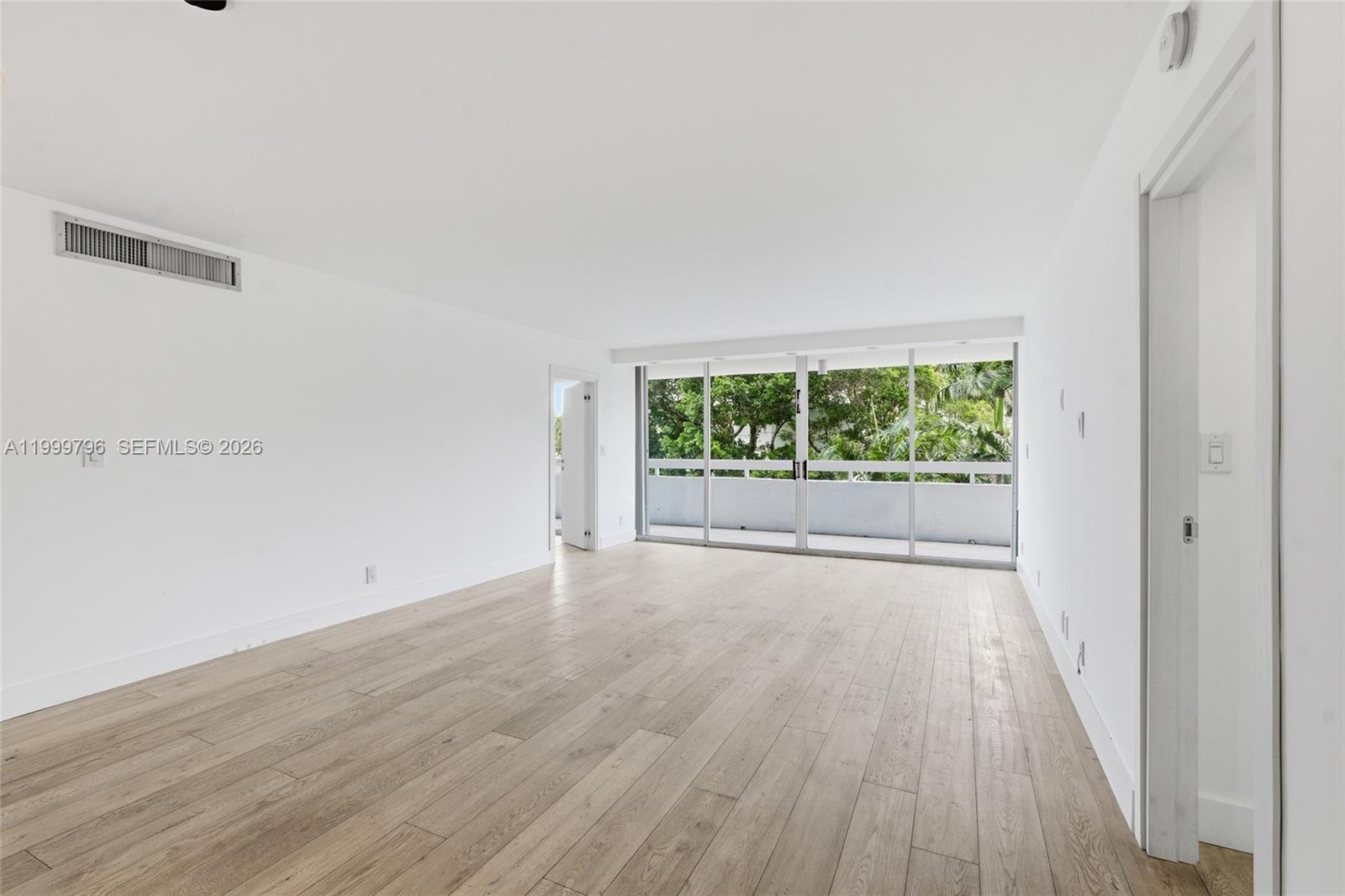 1627 Brickell Avenue, Unit 603 Miami, FL 33129 - Photo 3 of 29 a view of an empty room with wooden floor and a window