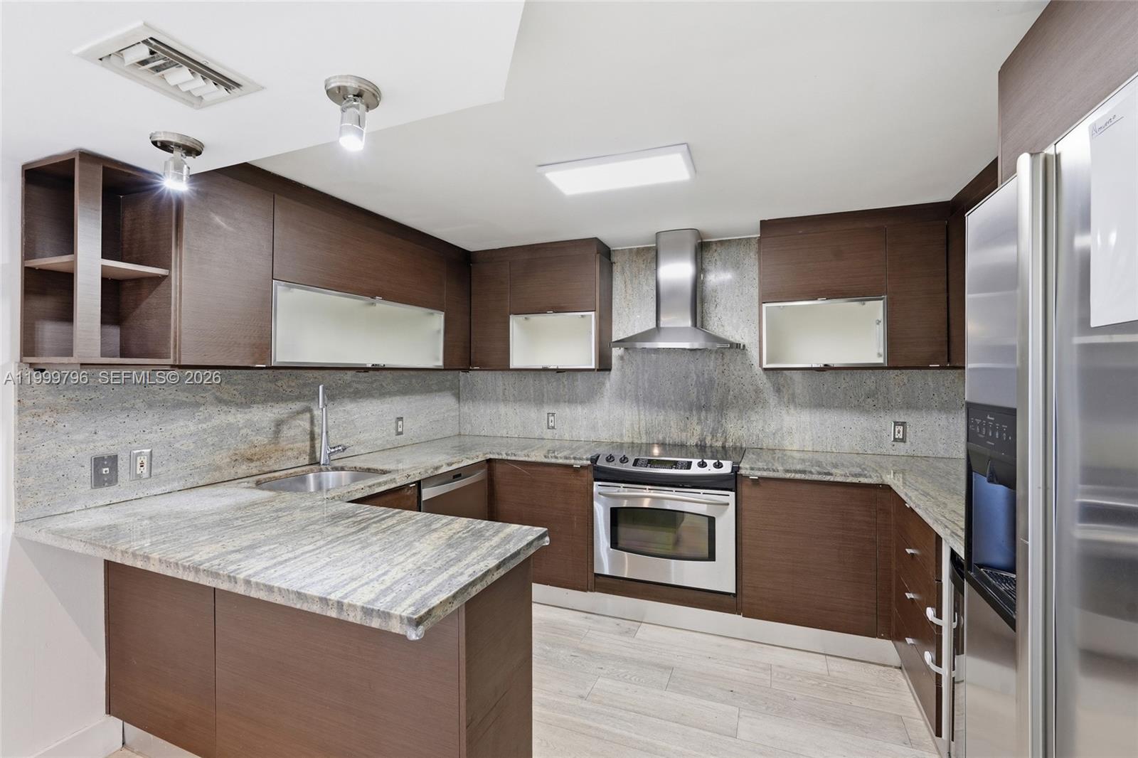 1627 Brickell Avenue, Unit 603 Miami, FL 33129 - Photo 5 of 29 a kitchen with stainless steel appliances granite countertop a sink stove and cabinets