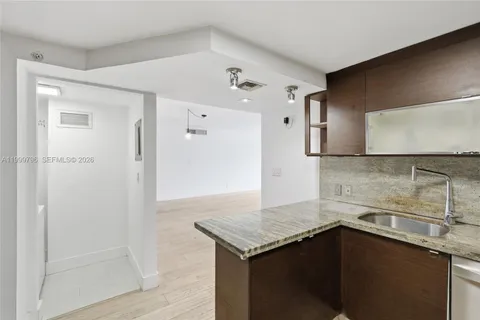 a kitchen with a sink a refrigerator and cabinets