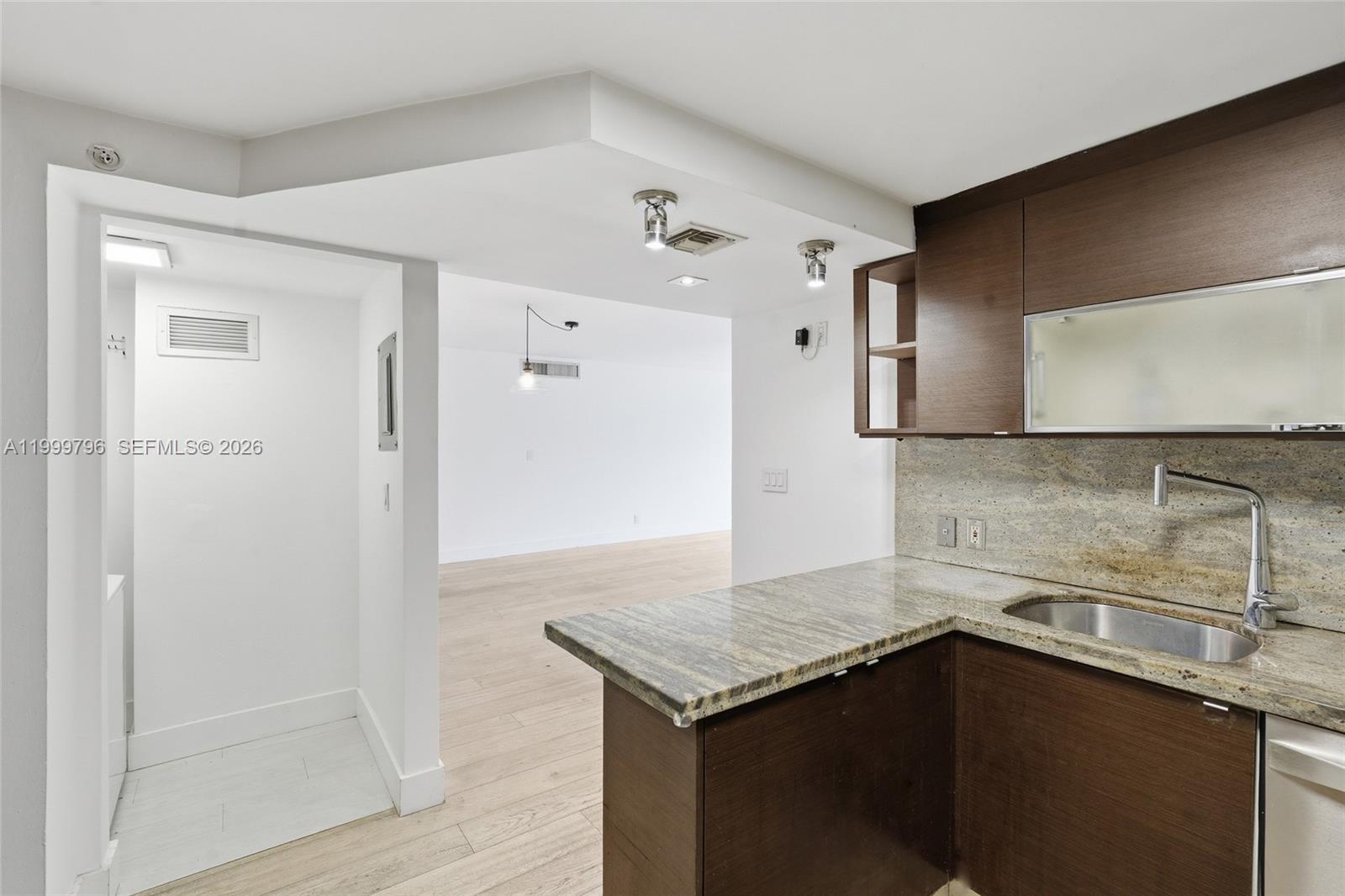 1627 Brickell Avenue, Unit 603 Miami, FL 33129 - Photo 7 of 29 a kitchen with a sink a refrigerator and cabinets