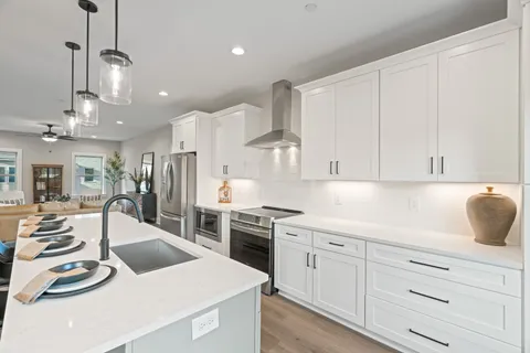 a kitchen with stainless steel appliances granite countertop a sink a stove a refrigerator and cabinets