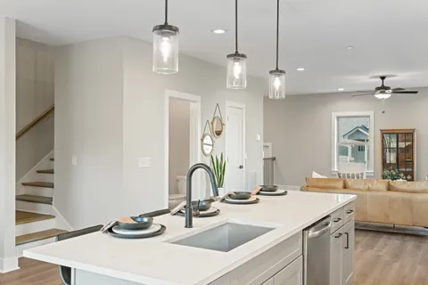 a kitchen that has a lot of cabinets chairs and wooden floor
