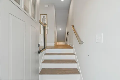 a view of a hallway with dining room and wooden floor