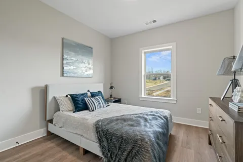 a bedroom with a bed and a dresser with mirror