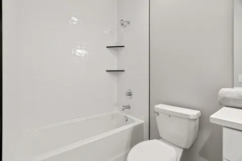 a bathroom with a toilet and a bath tub