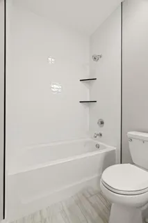 a large white kitchen with a stove a sink dishwasher and a microwave oven with white countertops