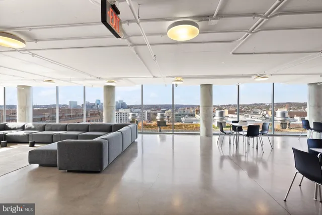 a dining room with furniture a floor to ceiling window and plants
