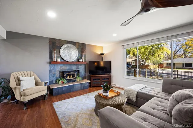 a living room with furniture a fireplace and a large window