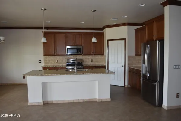 a kitchen with kitchen island a counter top space stainless steel appliances and cabinets