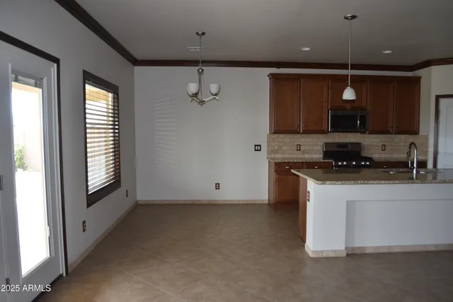 a view of kitchen with granite countertop stove top oven and sink