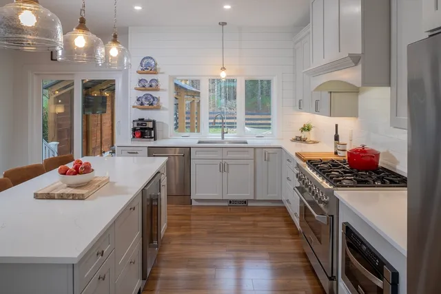 a kitchen that has a sink a stove and a wooden floor