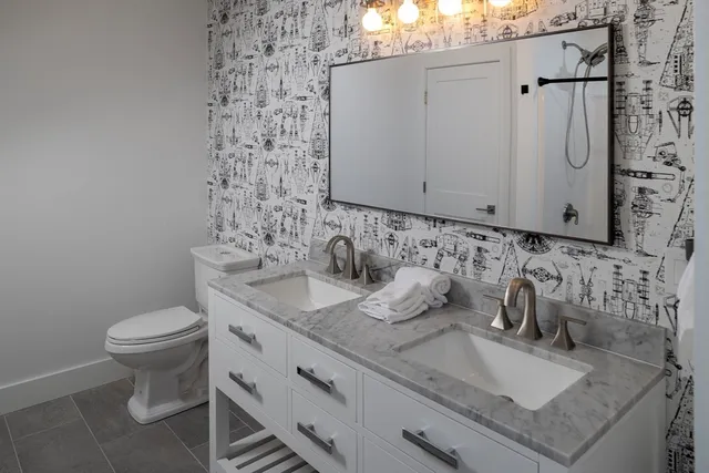 a bathroom with a granite countertop sink and a toilet