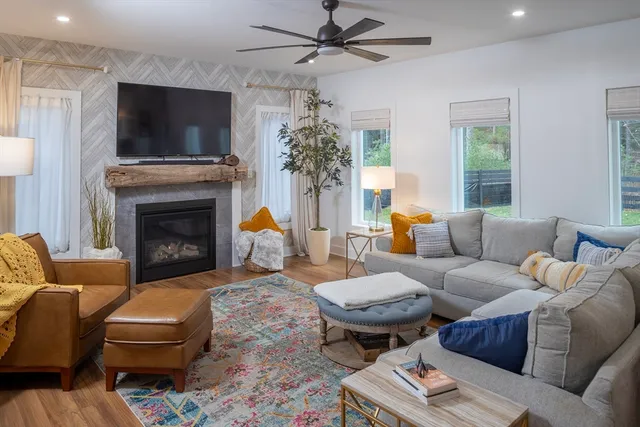 a living room with furniture a flat screen tv and a fireplace