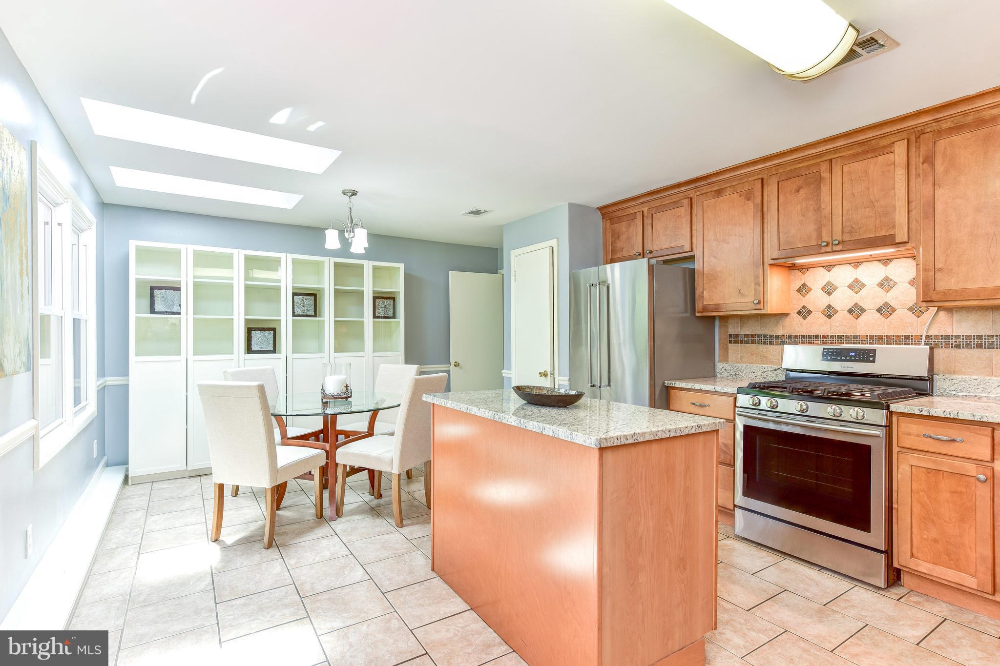 7201 Fort Hunt Road Alexandria, VA 22307 - Photo 4 of 30 a kitchen with stainless steel appliances granite countertop a stove top oven a sink a dining table and chairs
