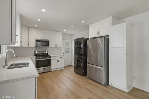 a kitchen with a refrigerator cabinets and wooden floor
