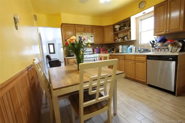 a kitchen with stainless steel appliances a stove a chimney a sink and cabinets