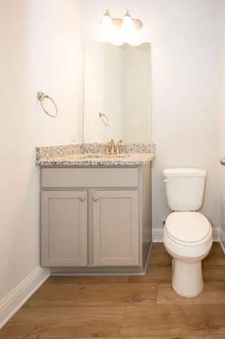 a bathroom with a granite countertop toilet a sink and mirror