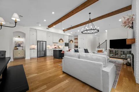 a living room with furniture kitchen view and a flat screen tv